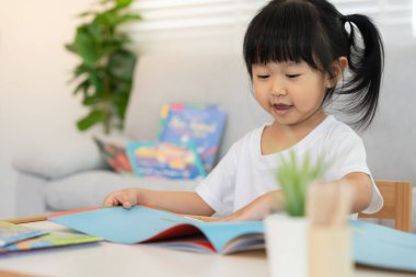 Mutlu Asyalı çocuklar evde kitap okuyarak rahatlar. Kızım ve bir hikaye okuyordum. öğrenme, çocuk bakımı, gülme, eğitim, hikaye anlatma, uygulama, hayal etme, bağımlılık cep telefonunu azaltma