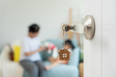 Taşınmak, taşınmak. Aile gülümsemesi ve yeni bir daire aldıktan sonra mutlu olmak, odanın içinde kişisel eşyalar ve mobilyalar içeren bir karton kutu vardı. yeni daireye taşınmak ya da taşınmak