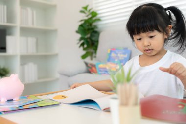 Mutlu Asyalı çocuklar evde kitap okuyarak rahatlar. Kızım ve bir hikaye okuyordum. öğrenme, çocuk bakımı, gülme, eğitim, hikaye anlatma, uygulama, hayal etme, bağımlılık cep telefonunu azaltma