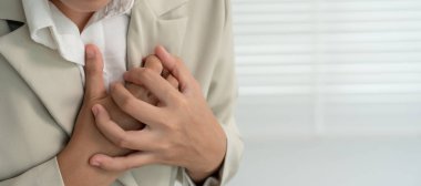 Göğsünde kalp krizi belirtileri olan el ele tutuşmalar, çok çalışan iş kadınlarının göğüs ağrıları kalp hastalığı, sızıntı, genişleme, genişlemiş kalp, göğsüne acı verici bir ifadeyle bastırma.