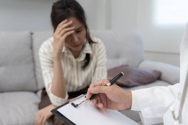 Akıl sağlığı sorunları olan bir kadın danışmanlık yapıyor. Psikiyatrist tedavi için hastanın durumunu kaydediyor. teşvik, sevgi ve aile sorunu, bipolar, depresyon hastası, intiharı koru