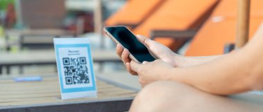 Woman use smartphone to scan QR code to pay in cafe restaurant with a digital payment without cash. Choose menu and order accumulate discount. E wallet, technology, pay online, credit card, bank app.