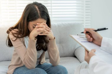 Akıl sağlığı sorunları olan bir kadın danışmanlık yapıyor. Psikiyatrist tedavi için hastanın durumunu kaydediyor. teşvik, sevgi ve aile sorunu, bipolar, depresyon hastası, intiharı koru