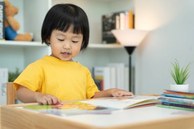 Mutlu Asyalı çocuklar evde kitap okuyarak rahatlar. Kızım ve bir hikaye okuyordum. öğrenme, çocuk bakımı, gülme, eğitim, hikaye anlatma, uygulama, hayal etme, bağımlılık cep telefonunu azaltma