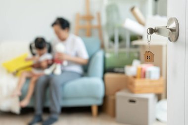 Taşınmak, taşınmak. Aile gülümsemesi ve yeni eve taşındıktan sonra birlikte oyun oynardık. Odanın içinde kişisel eşyalar ve mobilyalar içeren bir karton kutu vardı. Yeni daireye taşın, apartman dairesi.