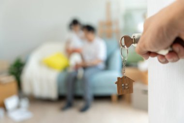 Taşınmak, taşınmak. Anne ve kızı gülümsüyor ve yeni eve taşındıktan sonra fotoğraf çekiyorlardı. Odanın içinde kişisel eşyalar ve mobilyalar olan bir karton kutu vardı. Yeni daireye taşın.