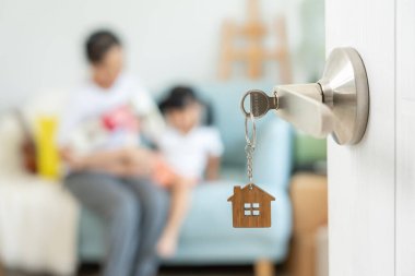 Taşınmak, taşınmak. Aile gülümsemesi ve yeni eve taşındıktan sonra birlikte oyun oynardık. Odanın içinde kişisel eşyalar ve mobilyalar içeren bir karton kutu vardı. Yeni daireye taşın, apartman dairesi.