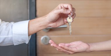 Kira, kiralama ve ev satma. Emlakçının elinde yeni sahibinin anahtarı var. Kira evi, Satış, Kredi Finansı, Sigorta, Satıcı, Satıcı, Taksit, Satın al, Sat, Taşı