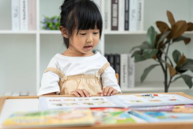 Mutlu Asyalı çocuklar evde kitap okuyarak rahatlar. Kızım ve bir hikaye okuyordum. öğrenme, çocuk bakımı, gülme, eğitim, hikaye anlatma, uygulama, hayal etme, bağımlılık cep telefonunu azaltma