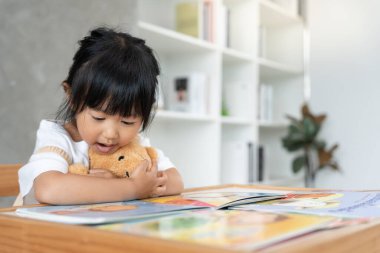 Mutlu Asyalı çocuklar rahatlayın ayı bebek için masal kitabı okuyun. Kızım ve bir hikaye okuyordum. öğrenim geliştirme, çocuk bakımı, eğitim, hikaye anlatma, uygulama, hayal etme, bağımlılığı azaltma cep telefonu