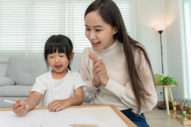 Happy Asia mother learning paint for little girl. family is happy and excited in the house. Mother and daughter having fun spending time together. Holiday, Activity, Executive Function, IQ, E