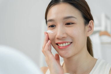 İyi cilt bakım kremi iyi cilt için kullanılır. Sağlıklı bir kadın yüzüne krem sürün ve makyaj yapın. Cilt kremi reklamı, kırışıklık önleyici, bebek yüzü, beyazlatma, nemlendirici.