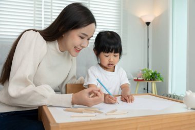 Mutlu Asya anneleri küçük kız için resim yapmayı öğreniyor. Komik aile evde mutlu ve heyecanlı. Anne ve kızı birlikte vakit geçiriyorlar. Tatil, Etkinlik