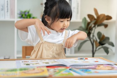 Mutlu Asyalı çocuklar evde kitap okuyarak rahatlar. Kızım ve bir hikaye okuyordum. öğrenme, çocuk bakımı, gülme, eğitim, hikaye anlatma, uygulama, hayal etme, bağımlılık cep telefonunu azaltma