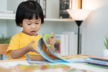 Mutlu Asyalı çocuklar evde kitap okuyarak rahatlar. Kızım ve bir hikaye okuyordum. öğrenme, çocuk bakımı, gülme, eğitim, hikaye anlatma, uygulama, hayal etme, bağımlılık cep telefonunu azaltma