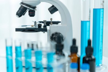 Bilimadamı ileri bilimsel laboratuvarda biyokimyasal örnekleri analiz ediyor. Tıbbi profesyonel kullanım mikroskobu virüsün mikrobiyolojik gelişimini gösteriyor. Fen laboratuvarında biyoteknoloji araştırması.