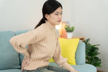 Kadın kendini tutuyor ve dayanılmaz ağrılar çekiyor. Sağlık ve sorunlar, kronik sırt ağrısı, ofis sendromunda sırt ağrısı, skolyoz, bel fıtığı, kas iltihabı.