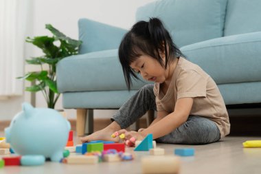 Mutlu Asyalı çocuk oyun oynuyor ve oyuncak bloklarını öğreniyor. Çocuklar evde çok mutlu ve heyecanlı. Çocuk oyun oynarken, etkinliklerde, gelişimde, dikkat eksikliğinde hiperaktivite bozukluğunda harika zaman geçirir.