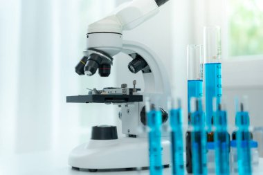 Bilimadamı ileri bilimsel laboratuvarda biyokimyasal örnekleri analiz ediyor. Tıbbi profesyonel kullanım mikroskobu virüsün mikrobiyolojik gelişimini gösteriyor. Fen laboratuvarında biyoteknoloji araştırması.