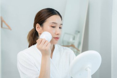 Güzel Asyalı kadınlar gözeneklerini sıkmak için aletler kullanır. Sağlıklı yüzler. Yüz bakımı ve tedavisi. Deri reklamı. Yüz kremi, kırışıklık önleyici, bebek yüzü, beyazlatma, nemlendirici, gözenek sıkılaştırıcı serum.