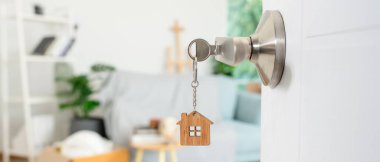 Taşınmak, taşınmak. Anahtar yeni evin kapısına yerleştirilmiş, odanın içinde kişisel eşyalar ve mobilyalar içeren bir karton kutu vardı. Daireye taşın, banne