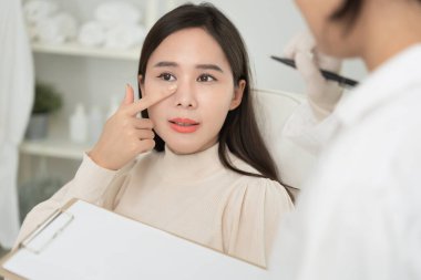 Estetik ameliyat, Asya gülümsemesi ve ameliyattan sonra mutlu olmak, burun şeklini değiştiren cerrahi prosedür, doktor burun ameliyatından önce hastanın burnunu muayene eder, tıbbi yardım, iyileşme.