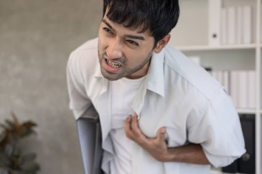 Göğüs kafesinde kalp krizi belirtileri var. Asyalı bir adamın göğüs ağrısı var. Kalp rahatsızlığı, sızıntı, genişleme, kalp büyümesi, göğsüne acı verici bir ifadeyle bastırma.