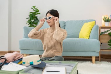 Gezgin. Dişi, güneş gözlüğünü yolculuk için hazırlıyor ve test ediyor. Kadınlar giysi ve kişisel eşyalardır. Yolculuktan önce bavullarınızı toplayın. tatil, tatil, uzun hafta sonu, özet