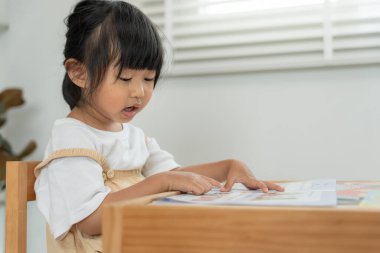 Mutlu Asyalı çocuklar evde kitap okuyarak rahatlar. Kızım ve bir hikaye okuyordum. öğrenme, çocuk bakımı, gülme, eğitim, hikaye anlatma, uygulama, hayal etme, bağımlılık cep telefonunu azaltma