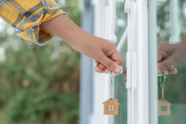 Evin kilidini açmak için ev sahibi anahtarı kapıya takılı. Kira ve satış için ikinci el ev. Sahibi el ile yeni ev için kapı ipoteğini açar, satın alır, satar, yeniler, yatırım, sahip, estat