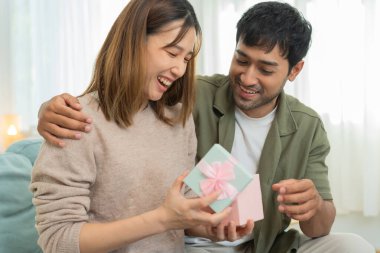 Güzel Asyalı kadın şaşırdı ve ilgi çekici hediye kutusuna baktı. Sevimli kız hediye kutusunu açtı. Doğum günü, kutlama, xmas, yeni yıl festivali, teşekkür, kutlama, sevgililer günü, yıldönümü