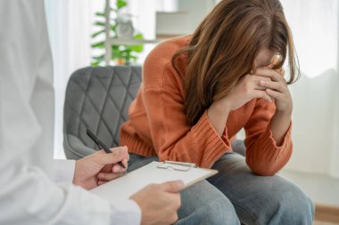 Akıl sağlığı sorunları olan bir kadın danışmanlık yapıyor. Psikiyatrist tedavi için hastanın durumunu kaydediyor. teşvik, sevgi ve aile sorunu, bipolar, depresyon hastası, intiharı koru