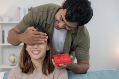 Mutlu koca sürpriz eş için hediye kutusu arar ve saklar. Sevimli kız, heyecanlı hediye kutusu. Doğum günü, kutlama, xmas, yeni yıl festivali, teşekkür, kutlama, sevgililer günü, evlilik yıldönümü 