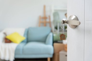 Moving house, relocation. The key was inserted into the door of the new house, inside the room was a cardboard box containing personal belongings and furniture. move in the apartment or condominiu