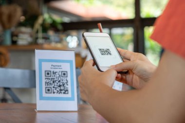 Woman use smartphone to scan QR code to pay in cafe restaurant with a digital payment without cash. Choose menu and order accumulate discount. E wallet, technology, pay online, credit card, bank app