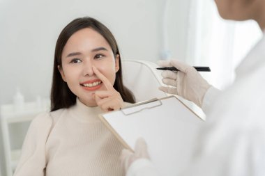 Estetik ameliyat, Asya gülümsemesi ve ameliyattan sonra mutlu olmak, burun şeklini değiştiren cerrahi prosedür, doktor burun ameliyatından önce hastanın burnunu muayene eder, tıbbi yardım, iyileşme.