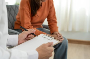 Akıl sağlığı sorunları olan bir kadın danışmanlık yapıyor. Psikiyatrist tedavi için hastanın durumunu kaydediyor. teşvik, sevgi ve aile sorunu, bipolar, depresyon hastası, intiharı koru