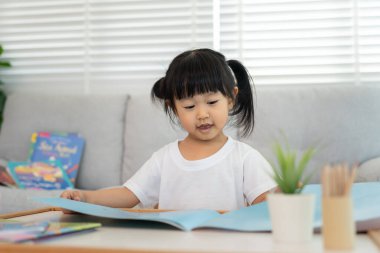 Mutlu Asyalı çocuklar evde kitap okuyarak rahatlar. Kızım ve bir hikaye okuyordum. öğrenme, çocuk bakımı, gülme, eğitim, hikaye anlatma, uygulama, hayal etme, bağımlılık cep telefonunu azaltma