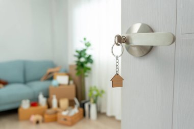 Moving house, relocation. The key was inserted into the door of the new house, inside the room was a cardboard box containing personal belongings and furniture. move in the apartment or condominium