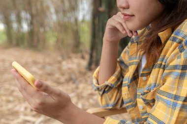 Neşeli genç Asyalı kadınlar bahçede oturur ve tatilin tadını çıkarırlar, eğlenirler, müzik dinlerler, kolunu kaldırırlar, en sevdiği şarkıyla dans ederler, güzel film müziklerinin tadını çıkarırlar, mutlu bir hayat, eğlenirler.