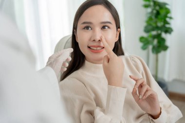 Plastik cerrahi, güzellik, cerrah ya da kadın yüzüne dokunan güzellik uzmanı, burun şeklini değiştiren cerrahi müdahale, doktor burun estetiğinden önce hastayı muayene eder, tıbbi yardım, iyileşme...