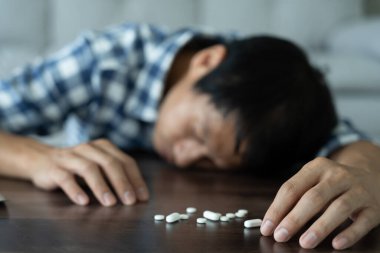 Adam aşırı dozda hap kullanıyor, stresli, üzgün, uyuşturucu bağımlısı, uyuşturucu bağımlısı, hasta, sağlıksız, mutsuz, intihar, depresyon veya ümitsiz, uyuşturucu bağımlısı, yaşam ve aile sorunları, motivasyonsuz