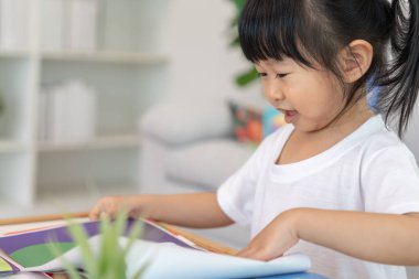 Mutlu Asyalı çocuklar evde kitap okuyarak rahatlar. Kızım ve bir hikaye okuyordum. öğrenme, çocuk bakımı, gülme, eğitim, hikaye anlatma, uygulama, hayal etme, bağımlılık cep telefonunu azaltma