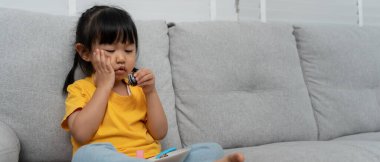 Çocuk tatlı yedikten sonra yanak yanağa bastırıyor, diş ağrısı çekiyor. Diş çürümesi, diş sorunları, çocuk duyguları ve yüz ifadesi, ağız sağlığı hizmetleri, florin kaplama, şekerleri azalt