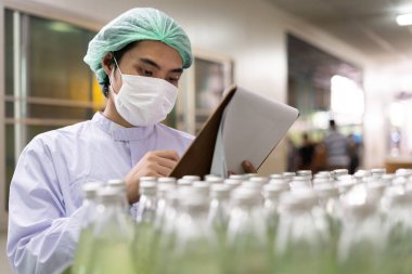 Müşteriye ürün göndermeden önce kalite kontrol gıdaları veya içecekler hakkında teknisyen teftişi. Üretim lideri malzeme ve verimliliği yeniden kontrol etti.