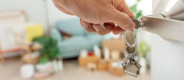 Taşınmak, taşınmak. Adam yeni daire için anahtarlık kullanıyor. Yeni evine taşın. Emlak al ya da kirala. konut kirası, kiralık mülk, yeni ev sahibi, yatırım, konut, kredi, ipotek.