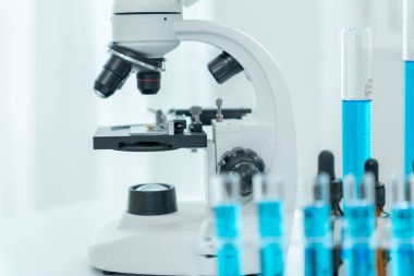 Bilimadamı ileri bilimsel laboratuvarda biyokimyasal örnekleri analiz ediyor. Tıbbi profesyonel kullanım mikroskobu virüsün mikrobiyolojik gelişimini gösteriyor. Fen laboratuvarında biyoteknoloji araştırması