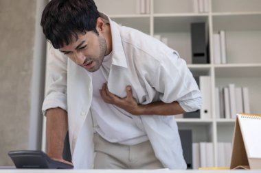 Göğüs kafesinde kalp krizi belirtileri var. Asyalı bir adamın göğüs ağrısı var. Kalp rahatsızlığı, sızıntı, genişleme, kalp büyümesi, göğsüne acı verici bir ifadeyle bastırma.