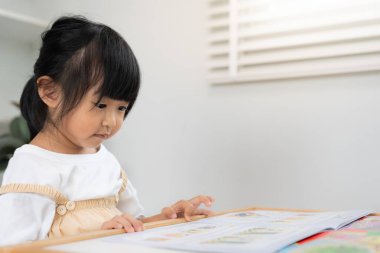 Mutlu Asyalı çocuklar evde kitap okuyarak rahatlar. Kızım ve bir hikaye okuyordum. öğrenme, çocuk bakımı, gülme, eğitim, hikaye anlatma, uygulama, hayal etme, bağımlılık cep telefonunu azaltma