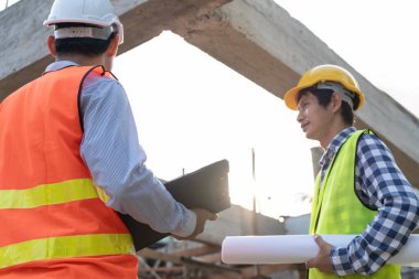 Müfettiş ya da mühendis bilgisayar kullanarak yeni ev inşaatını ve kalite güvencesini denetliyor. Mühendisler, mimarlar ya da irtibat görevlileri ev sahibine teslim etmeden önce evi inşa etmek için çalışıyorlar.